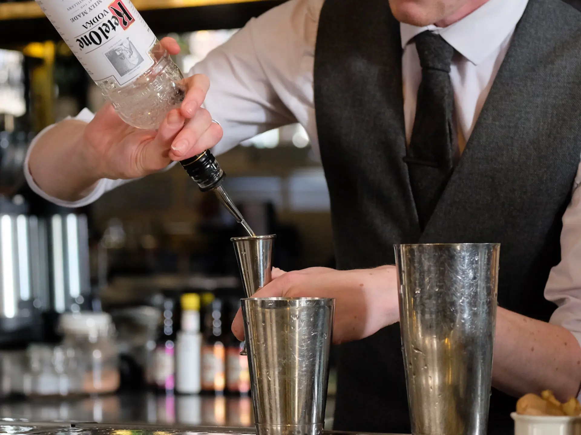 Ketel One High Bottle Neck Bartender Pouring max-h-[136px] max-w-[176px] object-contain bottle from Nolet Distillery