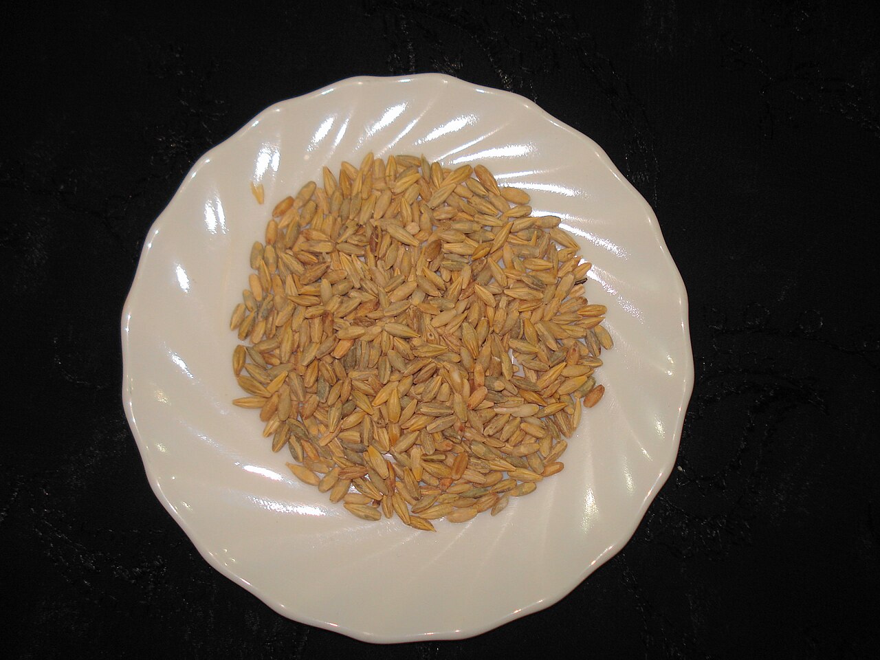 Barley grains gathered beside ripe barley ears